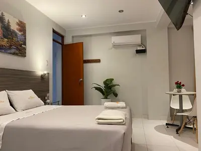 a bedroom with a white bed and a table at Millennium Hotel Corporative in San Vicente de Cañete