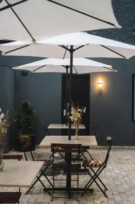 a table and chairs with a white umbrella at The Lot Boutique in Lima