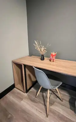 a wooden desk with a chair and a vase of flowers at The Lot Boutique in Lima