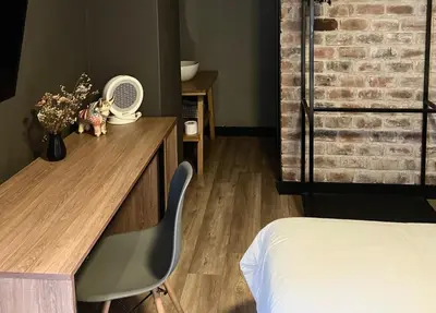 a bedroom with a bed and a desk with a fan at The Lot Boutique in Lima