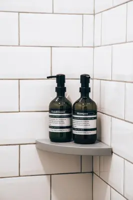 two bottles of soap sitting on a shelf in a bathroom at The Lot Boutique in Lima