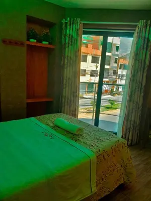 a bedroom with a bed and a large window at HOTEL LA BELLA Y EL LEON in Huánuco