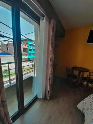 a room with a large sliding glass door with a table at HOTEL LA BELLA Y EL LEON in Huánuco