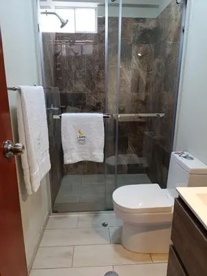 a bathroom with a glass shower with a toilet at Arabian Hotel in Lima
