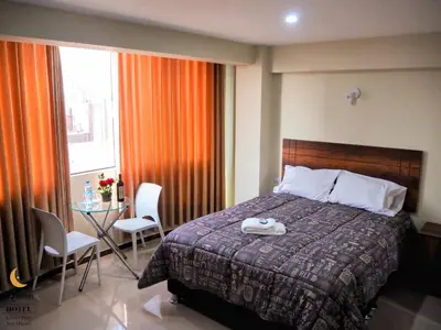 a bedroom with a bed and a table with chairs at Arabian Hotel in Lima