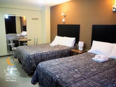 a hotel room with two beds and a mirror at Arabian Hotel in Lima