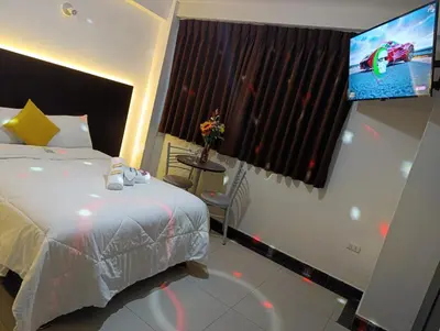 a bedroom with a bed and a flat screen tv at Arabian Hotel in Lima