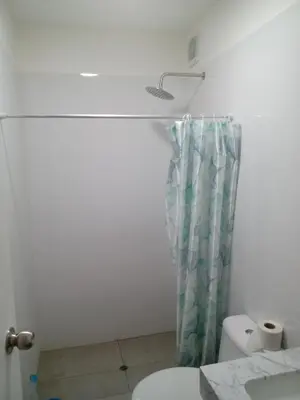 a bathroom with a toilet and a shower curtain at Habitación nueva para persona sola o pareja in Lima