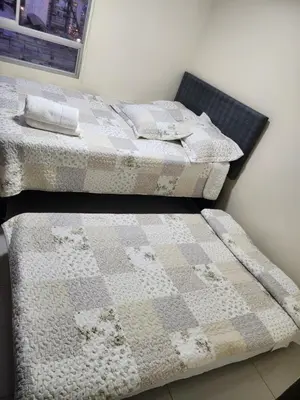 two beds sitting next to each other in a room at Departamento amplio y acogedor San Miguel in Lima