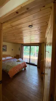 a bedroom with a bed and a large window at Oasis Blue Oxapampa in Palmira