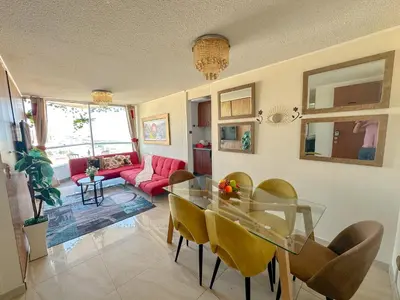 a living room with a glass table and yellow chairs at Departamento con vista al mar y piscina - Pool One in Lima