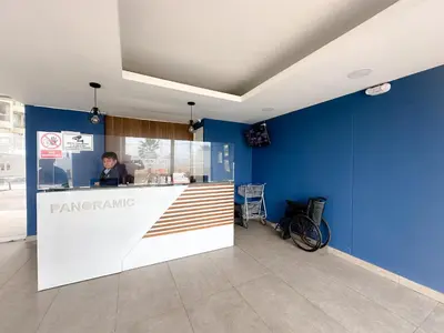 a man sitting at a bar in a blue wall at Departamento con vista al mar y piscina - Pool One in Lima