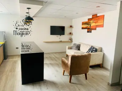 a living room with a couch and a tv at Apartamentos WANCA SUITES para 4, 5 y 6 huéspedes cochera muy cerca al Centro in Huancayo