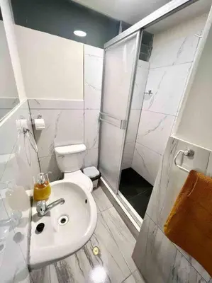 a white bathroom with a toilet and a sink at Apartamentos WANCA SUITES para 4, 5 y 6 huéspedes cochera muy cerca al Centro in Huancayo