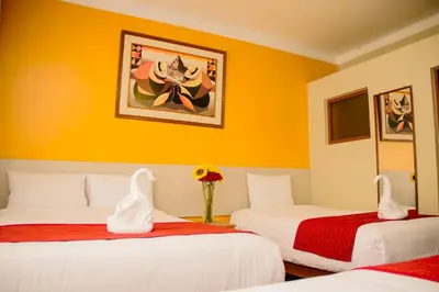 two beds in a room with yellow walls at HOSTAL CASA INKAS in Cusco