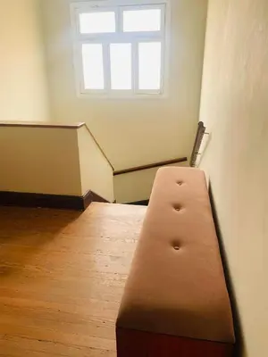 a brown bench in a room with a window at Peruvian House - Miraflores in Lima