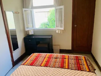 a bedroom with a bed and a window and a desk at Peruvian House - Miraflores in Lima