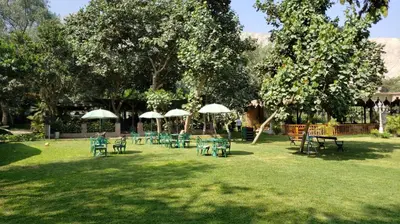 a group of tables and umbrellas in a park at Hacienda Santa María de Cieneguilla in Cieneguilla