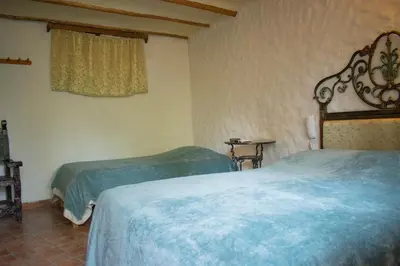 a bedroom with two beds and a window at Hacienda Santa María de Cieneguilla in Cieneguilla
