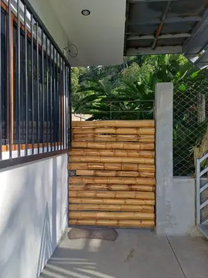 a wooden fence in front of a house at El Cacaotal Finca Faura #5 3H in San Ramón