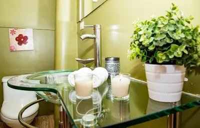 a bathroom with a glass counter with candles and plants at Kori Gems Inn in Cusco