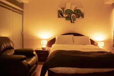 a bedroom with a large bed and a couch at Hotel B&V in Huancayo