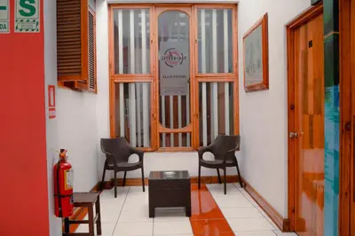 a hallway with three chairs and a fire extinguisher at Yaki Hostel in Lima