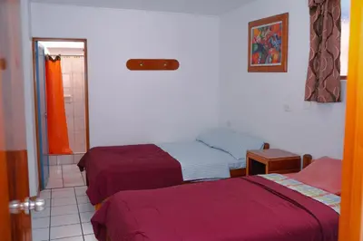 a bedroom with two beds and a bathroom at Yaki Hostel in Lima