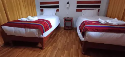 two beds sitting next to each other in a room at Raymi MachuPicchu in Machu Picchu