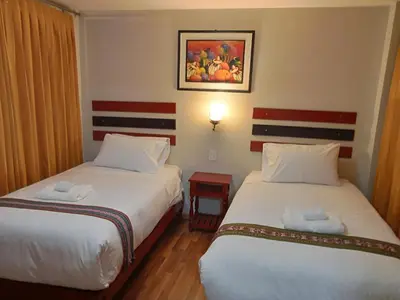 a hotel room with two beds and a picture on the wall at Raymi MachuPicchu in Machu Picchu