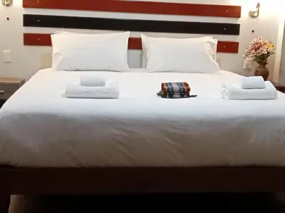 a large white bed with two towels on it at Raymi MachuPicchu in Machu Picchu