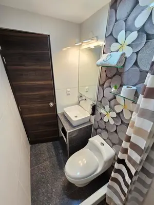 a bathroom with a toilet and a sink and a mirror at EL FARO HOTEL in Chala