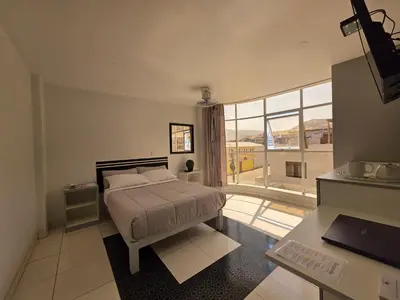 a bedroom with a bed and a large window at Hotel Real San Pedro in El Puente