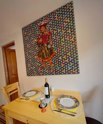 a table with two plates and a painting on the wall at Kintu Apartamento cusco in Cusco