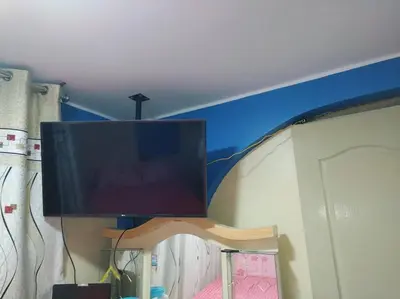 a flat screen tv hanging from a ceiling at Mi hermosa Casita con baño y cocina privados in Lima