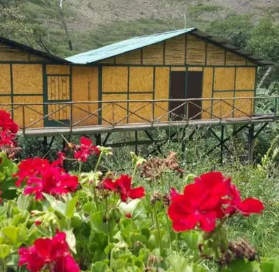 a house with red flowers in front of it at Araplay Lodge in Santa Teresa