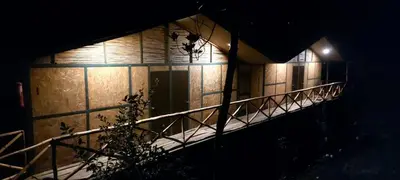 a building with a staircase lit up at night at Araplay Lodge in Santa Teresa