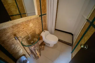 a small bathroom with a toilet and a sink at Araplay Lodge in Santa Teresa