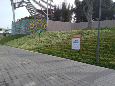 a sign on the side of a sidewalk next to a park at Like/Home in Lima