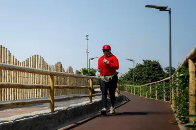 a man is walking down a road with a skateboard at Like/Home in Lima