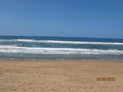 a person walking on the beach near the ocean at Like/Home in Lima