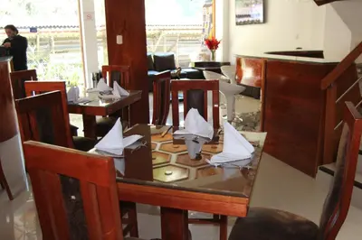 a dining room with a table with papers on it at Flower's House MachuPicchu in Machu Picchu
