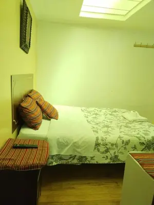 a bedroom with a large bed and a table at Hospedaje Apu Salka in Cusco