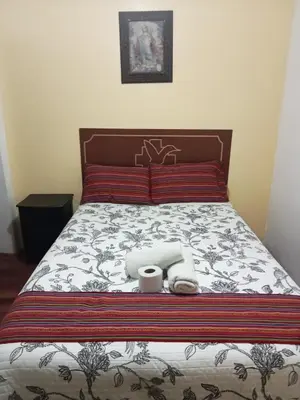 a bed with two towels and two cups on it at Hospedaje Apu Salka in Cusco