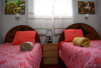 two beds in a bedroom with red pillows at Carlos Guest House Cusco in Cusco