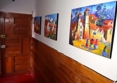a room with three paintings on the wall at Carlos Guest House Cusco in Cusco