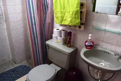 a small bathroom with a toilet and a sink at Carlos Guest House Cusco in Cusco