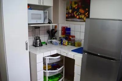 a kitchen with a counter top with a refrigerator at Carlos Guest House Cusco in Cusco