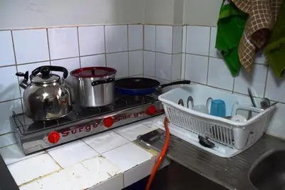 a kitchen with a stove with pots and pans on it at Carlos Guest House Cusco in Cusco