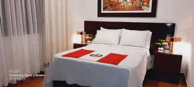 a bedroom with a bed with red and white sheets at HOSPEDAJE TURISTICO CHORRILLOS Sueños de Luna INN in Lima